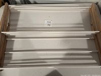 Top-down view of clothes drying rack showing wooden sides and white horizontal rods