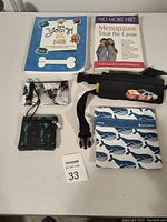 Photo shows two books, two small women's purses or cardholders, one insulated whale patterned lunch bag, and one black bag with car patches.