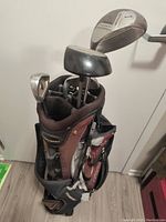 Golf bag full of golf clubs, showing club heads and bag compartments