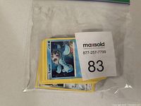 Photo of a plastic bag containing a stack of Pokémon trading cards with the top card being a Lapras card.