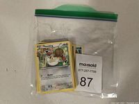 Stack of Pokemon trading cards in a clear ziplock bag, showing a Fletchling card on top with excellent condition.