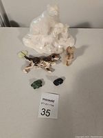 Photo shows a large unpainted white ceramic bear figurine with two cubs, plus five smaller Wade ceramic animal figurines in various colors including brown, tan, green, and blue, displayed on a flat surface.