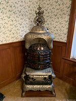 Front view of entire ornate cast iron and copper baseburner stove