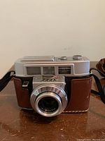 Front view of Kodak Automatic 35F camera showing lens, viewfinder, and attached leather case.