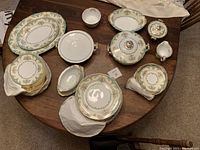 Overview of dinnerware pieces arranged on table including plates, bowls, platters and serving items.