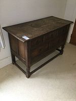 Three-quarter front view of oak sideboard showing overall structure and four-drawer configuration