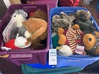 Photo of two bins filled with assorted stuffed bears and plush animals including a patriotic patch bear and a white eagle.