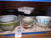 Full view showing all bowls and casserole dishes arranged on a shelf, displaying variety of patterns and styles
