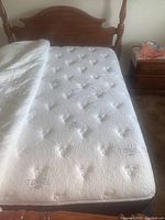 Top view of a white Englander Symbol queen mattress with tufted quilting and no visible stains, showing fabric labeled Tencel.