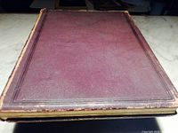 Top front cover of the antique Figaro Illustre book showing dark brown leather with embossed vertical frame lines and edge wear.