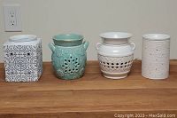 Front view of four wax warmers showing their distinct designs and colors.