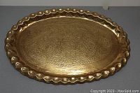 Full view of oval brass tray showing scalloped pie crust edge and engraved central floral pattern