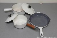 Top view showing two saucepans with lids and frying pan laid out