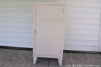 Front view of the closed metal cabinet showing white paint and simple design.