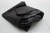 Folded black air mattress with attached carrying bag, showing size and portability.
