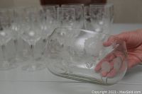 Photo showing close-up of medium sized lidded bowl with etched Corn Flower floral pattern and a hand holding it to show scale and detail.