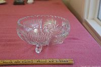 Front angle photo of the 9-inch lead crystal bowl on a pink surface with a ruler for scale, showing cut and etched patterns and tripod base.