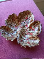 Ceramic tray shaped as a maple leaf with mottled glaze, showing its shape and color.