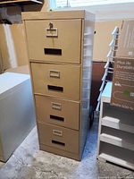 Full front view of the beige four drawer filing cabinet showing drawer handles, label holders, and lock on top drawer.