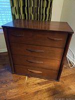 Front view of the dresser showing three drawers and the smooth wooden top with no feet attached.