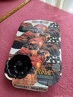 Mini-bundt pan with packaging showing various baked goods and heavy cast aluminum badge.