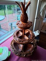Front view of full Tiki tray tower showing pineapple top, two tiers and snack compartments