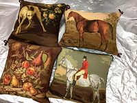 Four 12x12 needlepoint pillows including dog, horse, military man in red coat on white horse, and fruit.