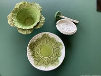 Overhead view of the soup tureen, lid, ladle, and serving platter showing vegetable-themed ceramic designs.