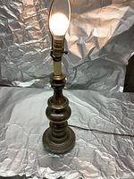 Full view of the 29-inch tall solid brass table lamp with light bulb illuminated.