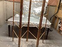 Full view of the wooden laundry drying rack set up in a basement or utility space showing wooden slats and metal connectors.