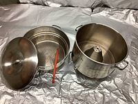 Complete steam processor juice extractor kit with base pot, steam basket, lid, and stirring paddle laid out on surface.