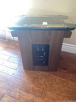 Side view of the laminate woodgrain cabinet with black metal coin door