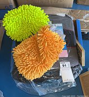 Two microfiber chenille car wash gloves in yellow-green and orange on top of a box.