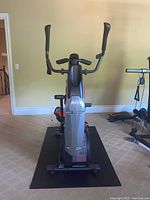 Front view of Bowflex Max Trainer M5 on black floor mat against beige wall