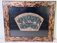 Full view of framed ceramic fan-shaped wall art in mottled gold and black wood shadow box frame.