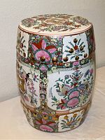 Full front view of cylindrical porcelain garden stool showing overall butterfly and chrysanthemum motif