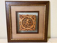 Framed Chinese wooden carving with "Long Life" symbol shown fully framed from the front.