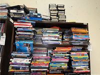 Stacked DVDs covering musicals, children’s films, and other entertainment titles