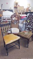 Three Eastlake style chairs with upholstered seats displayed in a room with other furniture, showing varied upholstery and chair back designs.