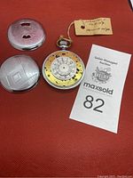 Watch opened with two detached case covers and exposed dial mechanism on red background.