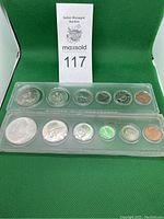 Two plastic holders each containing a complete set of Canadian coins from 1967 and 1970, showing front view of coins including dollar and smaller coin denominations.
