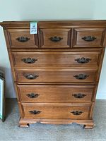 Front view of the dresser showing all four drawers with brass handles and detailed panels.