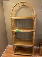 Full view of the bamboo shelving unit showing three shelves and rounded double arch design on top.