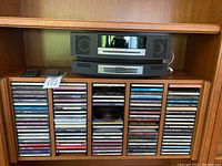Overall view of Bose units and CD collection in wooden cabinet