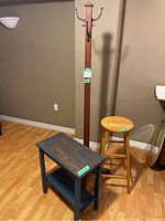 Photo showing all three items: coat rack, stool, and blue side table on wood flooring against a beige wall