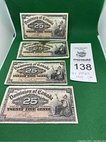 Four banknotes front side up with lot card on green background