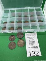 Plastic storage box with multiple Canadian coins in individual compartments