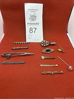 All 11 pins arranged showing various designs and colors on a red background.