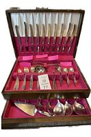 Full view of opened wooden box displaying knives, forks, spoons, servers arranged in felt-lined slots