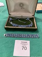 Vintage blue and crystal rhinestone necklace, earrings, and bracelet set displayed in green velvet-lined box with auction lot number card visible